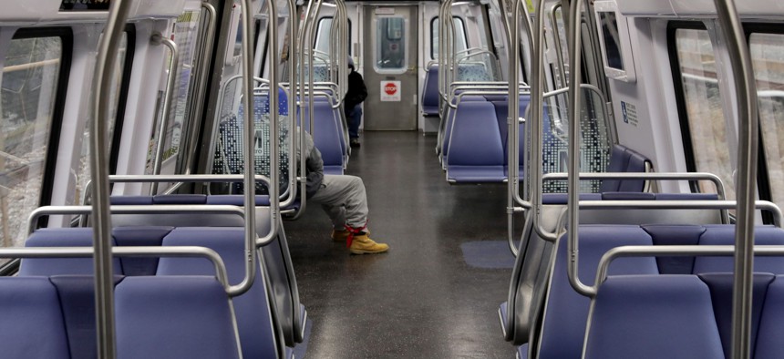 A commuter rides in nearly-empty Metro train car during rush hour in December 2020.