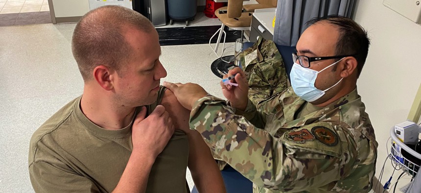 Staff Sgt. Adam Neill, an aircraft maintainer with the 191st Maintenance Squadron, receives a vaccination from Tech. Sgt. Michael Geise, a medic with the 127th Medical Group, at Selfridge Air National Guard Base, Michigan, Nov. 6, 2022.