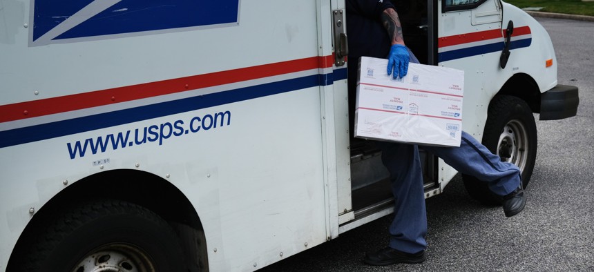  Postal Service worker Lou Martini goes about his daily delivery route during the coronavirus pandemic on April 15, 2020, in Kings Park, New York.