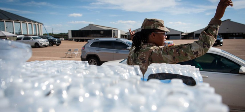 A National Guard directs traffic at a water distribution site at the Mississippi State Fairgrounds in Jackson in September 2022. 