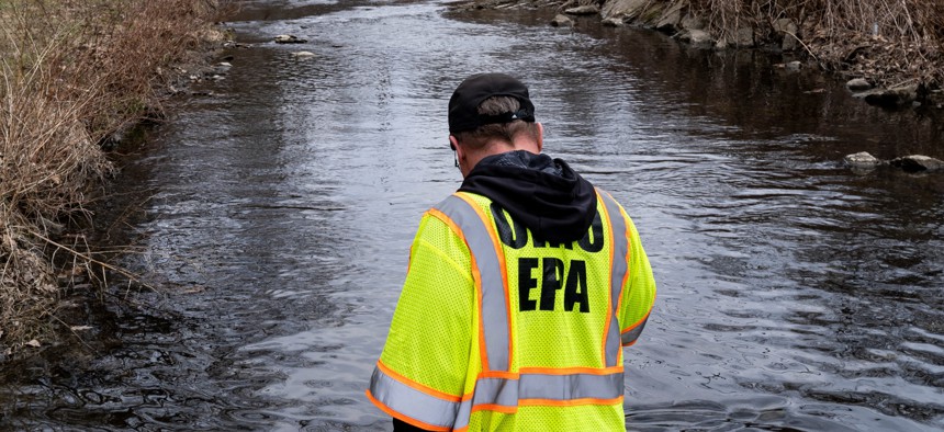 Ron Fodo, Ohio EPA Emergency Response, looks for signs of fish and also agitates the water in Leslie Run creek to check for chemicals in Ohio on Feb. 23.