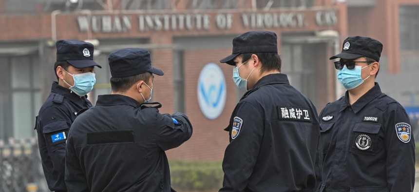 Security personnel stand guard outside the Wuhan Institute of Virology as members of the World Health Organization team investigating the origins of COVID-19 make a visit to the institute in Wuhan in China's central Hubei province on February 3, 2021. 