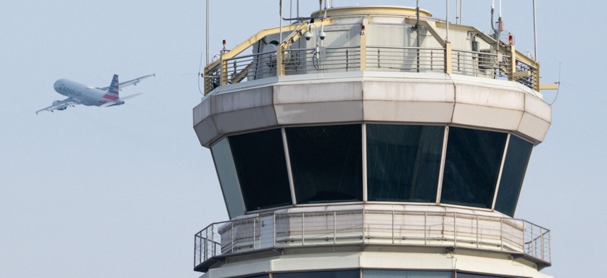 An American Airlines Airbus A319 airplane takes off past the air traffic control tower at Ronald Reagan Washington National Airport in Arlington, Va.