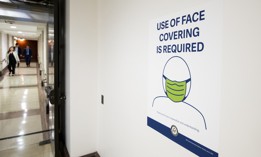 Staffers walk through the basement of the Capitol past a face masks required sign on on Monday, February 28, 2022.