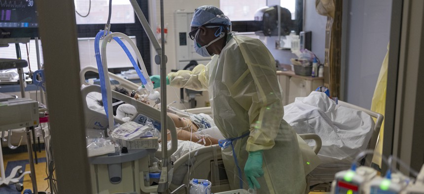 A nurse checks the temperature of a COVID-19 patient with an electronic device at the Medical Intensive Care Unit floor, at the Veterans Affairs Medical Center in Manhattan in 2020.