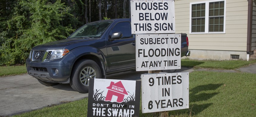 Signs warn potential homebuyers about flooding issues in the Starcreek Circle neighborhood of Myrtle Beach, S.C. on Sept. 19, 2022.