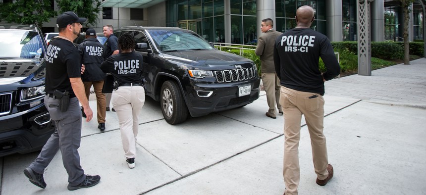 Internal Revenue Service agents walk toward a building in the Galleria area of Houston on May 20, 2022. The No Funds for Armed Regulators Act would eliminate officer positions at the IRS, Environmental Protection Agency and Labor Department. 