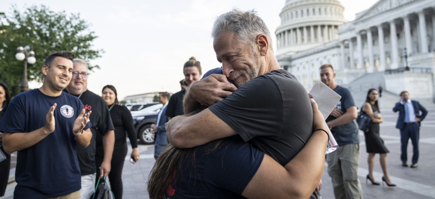 Comedian and activist Jon Stewart hugs Rosie Torres, wife of veteran Le Roy Torres who suffers from illnesses related to his exposure to burn pits in Iraq, after the Senate passed the PACT Act on Aug. 2, 2022.
