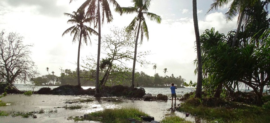 A resident walks through tidal water in Majuro Atoll, in the Marshall Islands on March 9, 2016. Residents in low-lying areas of the Marshall Islands were braced for ongoing flooding on March 11, as a series of inundations underscored the Pacific island nation's vulnerability to climate change.