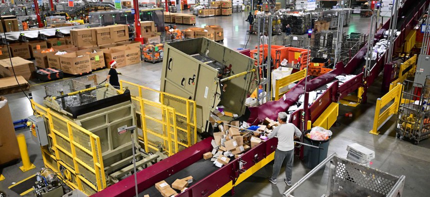 Postal Service employees sort mail at the Los Angeles Processing and Distribution Center on Nov. 30, 2022. The new cost-saving proposal will have to receive approval from the Postal Regulatory Commission. 