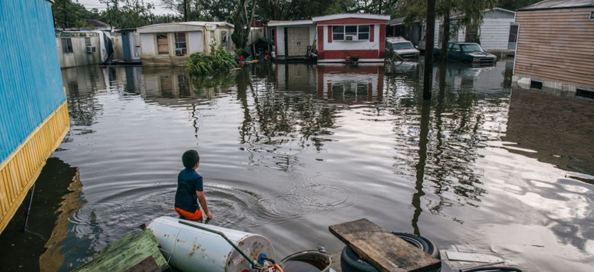 A boy, then 8 years old, stands in front of his grandfather's house after it was flooded during Hurricane Ida on Aug.31, 2021, in Barataria, Louisiana.