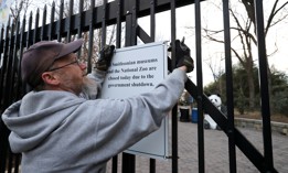A Smithsonian National Zoo employee removes a sign telling visitors that the zoo is closed due to a government shutdown from the front gate on Jan. 28, 2019. 