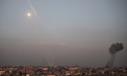 Rockets are fired by Palestinian militants toward Israel as smoke billows from the southern Gaza Strip, on Dec. 1. The U.S. Office of Special Counsel issued new guidance interpreting how federal employees are allowed to discuss the conflict under the Hatch Act.