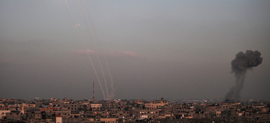Rockets are fired by Palestinian militants toward Israel as smoke billows from the southern Gaza Strip, on Dec. 1. The U.S. Office of Special Counsel issued new guidance interpreting how federal employees are allowed to discuss the conflict under the Hatch Act.