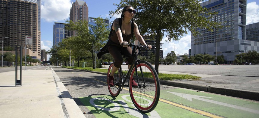 A bicyclist rides in a bike lane in downtown Houston.