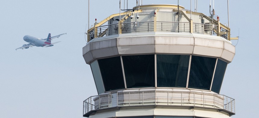 An American Airlines Airbus A319 airplane takes off past the air traffic control tower at Washington National Airport in Arlington, Va., on Jan.11, 2023. Control towers at airports are only the most visible parts of the complex national air traffic control system. 
