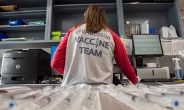 Home base primary care Pharmacist Erin Emonds logs onto a computer before filling syringes with COVID-19 vaccines at the VA Boston Healthcare System's Jamaica Plain Medical Center in March 2021.