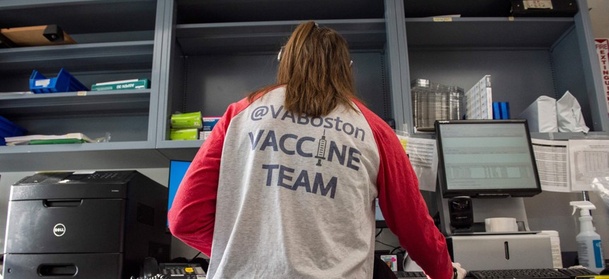 Home base primary care Pharmacist Erin Emonds logs onto a computer before filling syringes with COVID-19 vaccines at the VA Boston Healthcare System's Jamaica Plain Medical Center in March 2021.