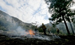 U.S. Forest Service firefighters in the Angeles National Forest burn piles of forest debris below Mt. Baldy on Nov. 29, 2023. Controlled burns are part of the service's forest management practices. 