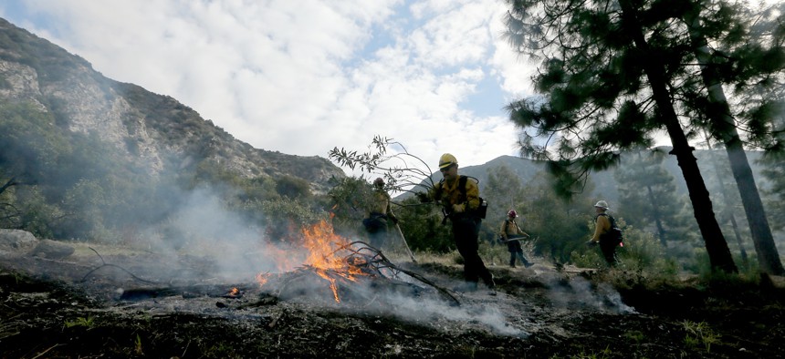 U.S. Forest Service firefighters in the Angeles National Forest burn piles of forest debris below Mt. Baldy on Nov. 29, 2023. Controlled burns are part of the service's forest management practices. 