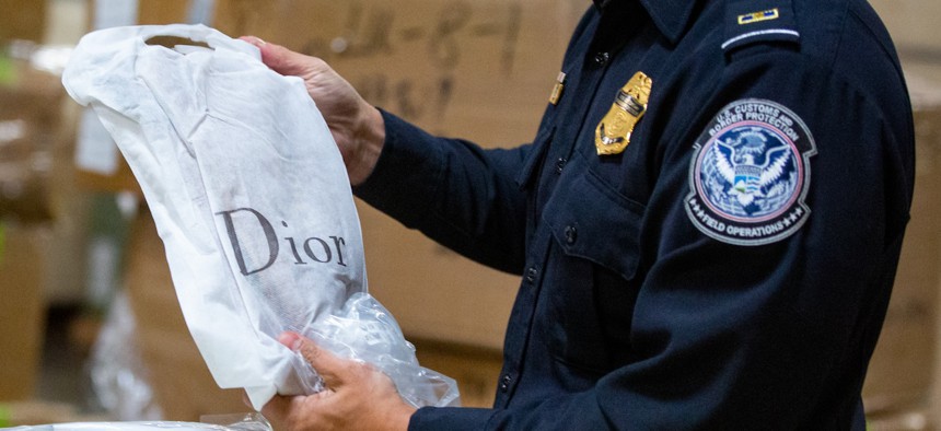 Customs and Border Protection officers inspect boxes of counterfeit products at the Los Angeles/Long Beach Seaport complex on Nov. 17, 2022 in Carson, Calif.
