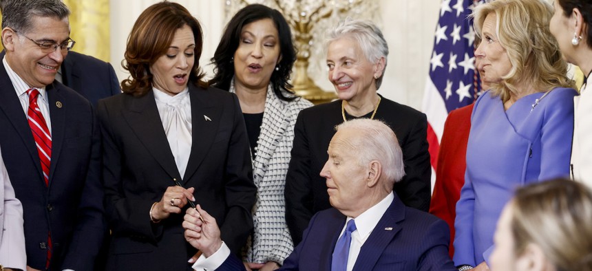 President Biden looks to Vice President Harris as he signs an executive order designated to the study of women's health during a Women’s History Month reception in the East Room of the White House on March 18, 2024.