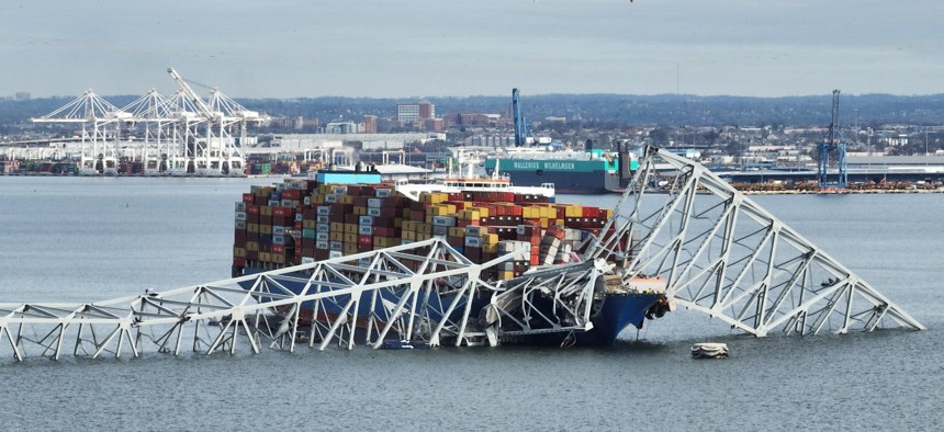 In this aerial image, the steel frame of the Francis Scott Key Bridge in Baltimore sits on top of a container ship after the bridge collapsed on March 26, 2024. The bridge collapsed early March 26 after being struck by the Singapore-flagged Dali container ship, sending multiple vehicles and people plunging into the frigid harbor below. There was no immediate confirmation of the cause of the disaster, but Baltimore's Police Commissioner Richard Worley said there was "no indication" of terrorism. 