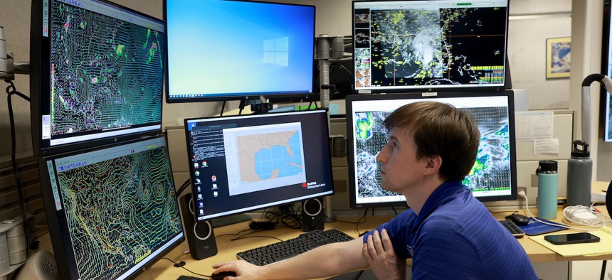 A worker at the National Hurricane Center tracks weather over the Gulf of Mexico. 
