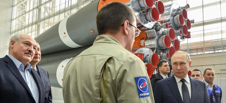 Russian President Vladimir Putin (R) speaks with a Roscosmos employee during a visit at the Vostochny cosmodrome on April 12, 2022.