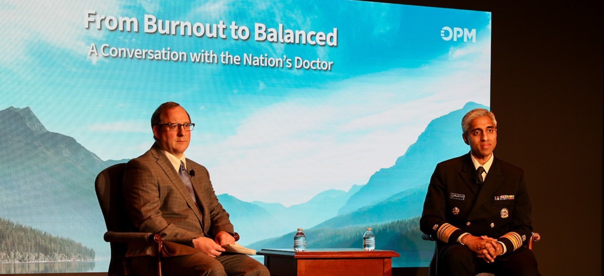 OPM acting Director David Shriver, left, and U.S. Surgeon General Vivek Murthy, right, discuss burnout among federal employees at an OPM event on May 9.