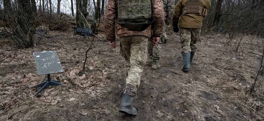 Soldiers of the Ukraine army's 95th Brigade walk past a Starlink satellite internet receiver on February 18, 2024 in Ukraine.