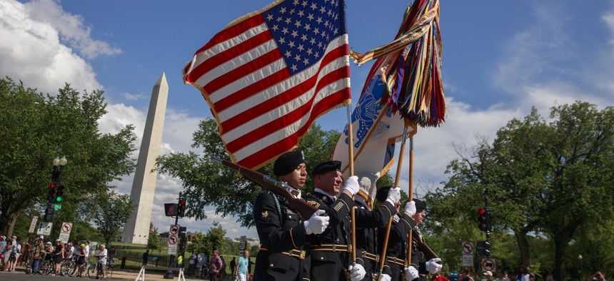 U.S. Army soldiers carry flags and streamers along Constitution Avenue during the National Memorial Day Parade in Washington, D.C., on May 27, 2019.
