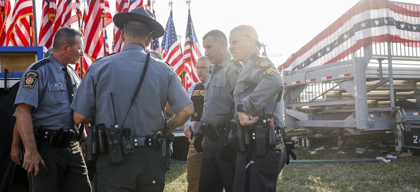 Law enforcement agents stand near the stage of a campaign rally for Republican presidential candidate former President Donald Trump on July 13 in Butler, Pa. According to Butler County District Attorney Richard Goldinger, the suspected gunman is dead after injuring Trump, killing one audience member and injuring at least one other.