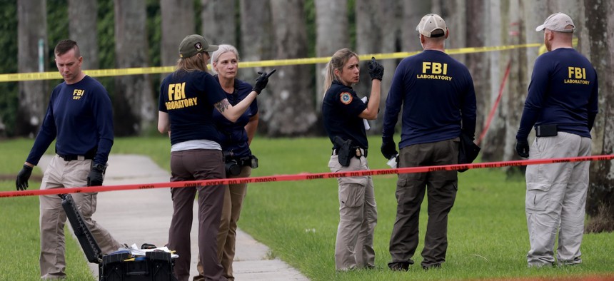 Law enforcement personnel continued to investigate the area around Trump International Golf Club on Monday after an apparent assassination attempt on former President Donald Trump a day earlier. The FBI is leading the investigation.