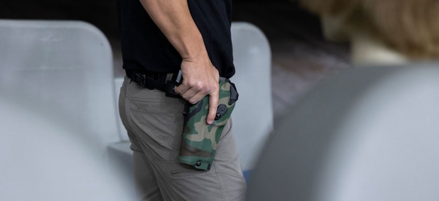 A federal air marshal service instructor prepares to draw his gun for a demonstration at a shooting range at the TSA training center in Atlantic City, N.J., on Nov. 7, 2023. The marshals are always on call and often have to work in 20-hour shifts.