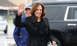 Democratic presidential nominee and US Vice President Kamala Harris waves after being greeted by Sen. Mark Kelly, D-Ariz., as she departs for the US-Mexico border from Joint Base Andrews in Maryland, Sept. 27, 2024. 