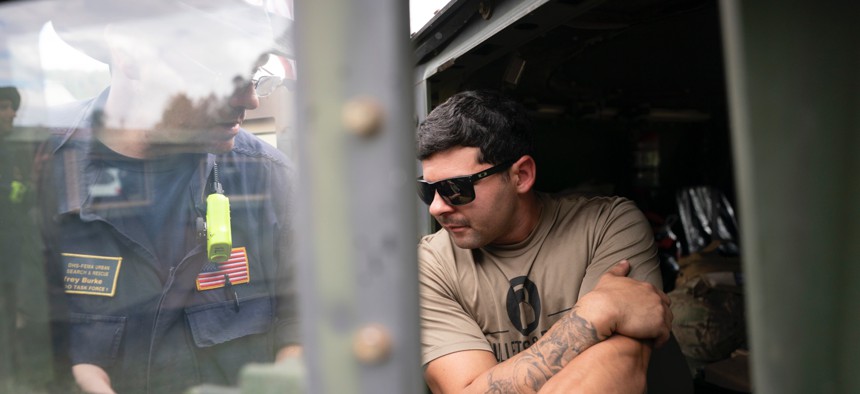 A FEMA response team member works with a guard member at Crooked Creek Fire Department near Old Fort in the aftermath of Hurricane Helene on Sept. 30 in Old Fort, North Carolina.