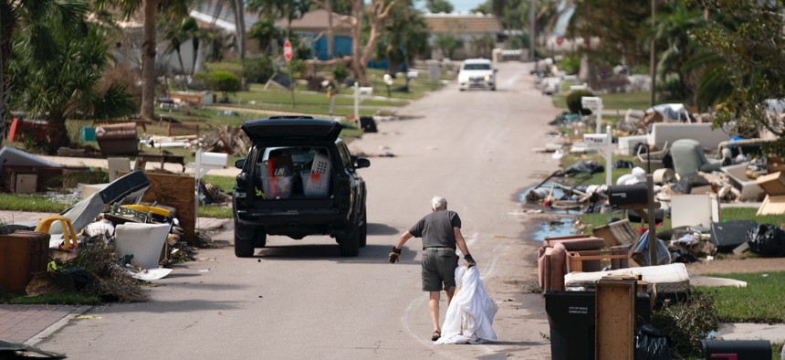 A man drags storm debris in the aftermath of Hurricane Milton on Oct. 10, 2024 in Englewood, Florida.