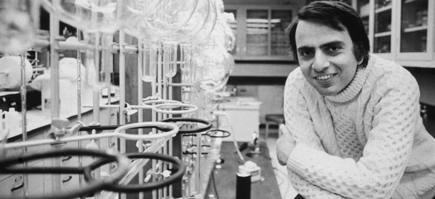 20th March 1974: Portrait of American astronomer and author Carl Sagan (1934 - 1996) leaning his elbows on his knees and smiling in a laboratory at Cornell University, Ithaca, New York. He is wearing a turtleneck sweater.