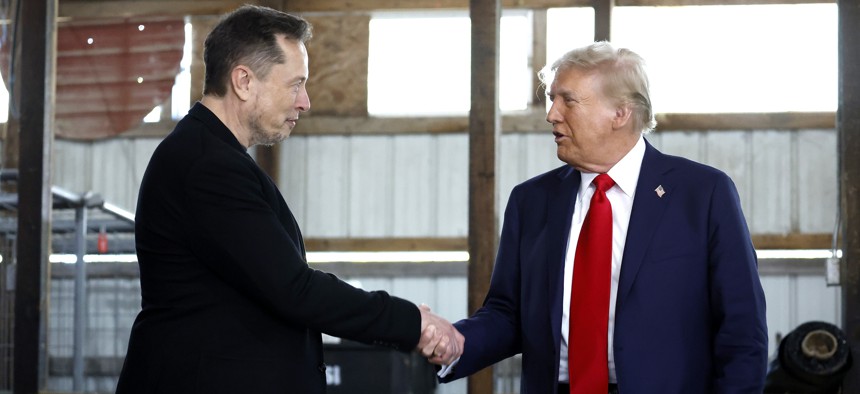 Elon Musk, left, shakes hands with former President Donald Trump back stage during a campaign rally at the Butler Farm Show grounds on Oct. 5, 2024. The president-elect has vowed to create a government efficiency commission under Musk that will recommend "drastic reforms."