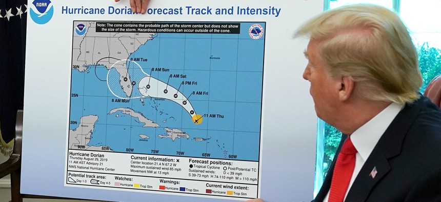 Then-President Donald Trump shows reporters a map altered with a marker to falsely indicate that Alabama was in danger from Hurricane Dorian, as Trump had tweeted and forecasters had contradicted, in September 2019.