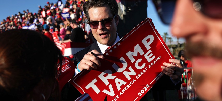 Rep. Matt Gaetz, R-Fla., prepares to sign a Trump-Vance sign at a campaign rally for former President Donald Trump on Oct. 12, 2024, in Coachella, Calif. Trump has picked Gaetz to lead the Justice Department. 