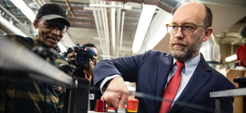 Acting OMB director Russ Vought presses the button that starts the machine that will print copies of President Donald Trump's proposed fiscal 2021 budget at the Government Publishing Office on Feb. 6, 2020. President-elect Trump is reported to have selected Vought to lead OMB again.