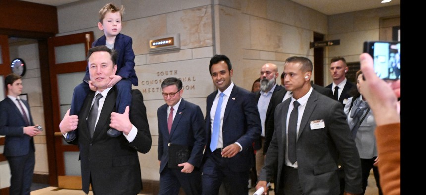 Tesla CEO Elon Musk, co-chair of the non-governmental Department of Government Efficiency, carries his son X on his shoulders, as he walks with Speaker of the House Mike Johnson (second from left) and Vivek Ramaswamy (center), before a meeting with members of Congress at the Capitol on Dec. 5, 2024.