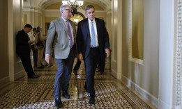 Sens. Tim Kaine, D-Va., (left) and Mark Warner, D-Va., head for a closed Democratic caucus meeting at the U.S. Capitol on Sept. 28, 2023. The two, along with Rep. Steny Hoyer, D-Md., led more than two dozen lawmakers in an appeal to the president to restore military-civilian pay parity.