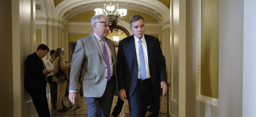 Sens. Tim Kaine, D-Va., (left) and Mark Warner, D-Va., head for a closed Democratic caucus meeting at the U.S. Capitol on Sept. 28, 2023. The two, along with Rep. Steny Hoyer, D-Md., led more than two dozen lawmakers in an appeal to the president to restore military-civilian pay parity.