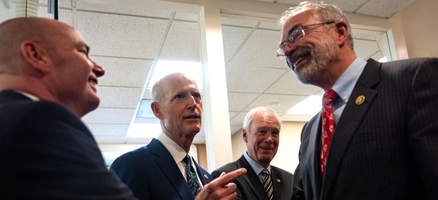 Rep. Andy Harris, R-Md., (right) chair  of the House Freedom Caucus is greeted by (left to right) Sens. Mike Lee, R-Utah, Rick Scott, R-Fla., and Ron Johnson, R-Wis., at the Capitol on Dec. 18, 2024. 