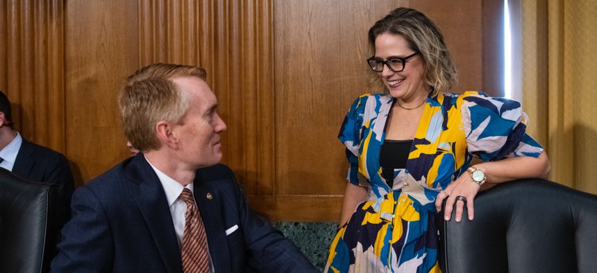 Sen. James Lankford, R-Okla., talks with Sen. Kyrsten Sinema, D-Ariz., prior to a Senate Committee on Finance hearing on Oct. 19, 2021. Lankford and Sinema's Chance to Compete Act will soon head to the president's desk.