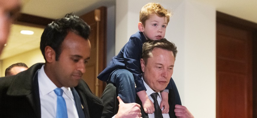 Tesla CEO Elon Musk (right), co-chair of the newly announced Department of Government Efficiency, carries his son on his shoulders at the U.S. Capitol following a meeting with businessman Vivek Ramaswamy (left), the other co-chair of the nongovernmental panel, and members of Congress, on Dec. 5, 2024.