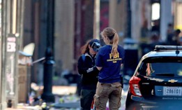 A member of the FBI's Evidence Response Team takes photographs on New Orleans' Bourbon Street following a New Year's Day attack in which an individual drove into a crowd. The FBI is surging agents to investigate the incident. 